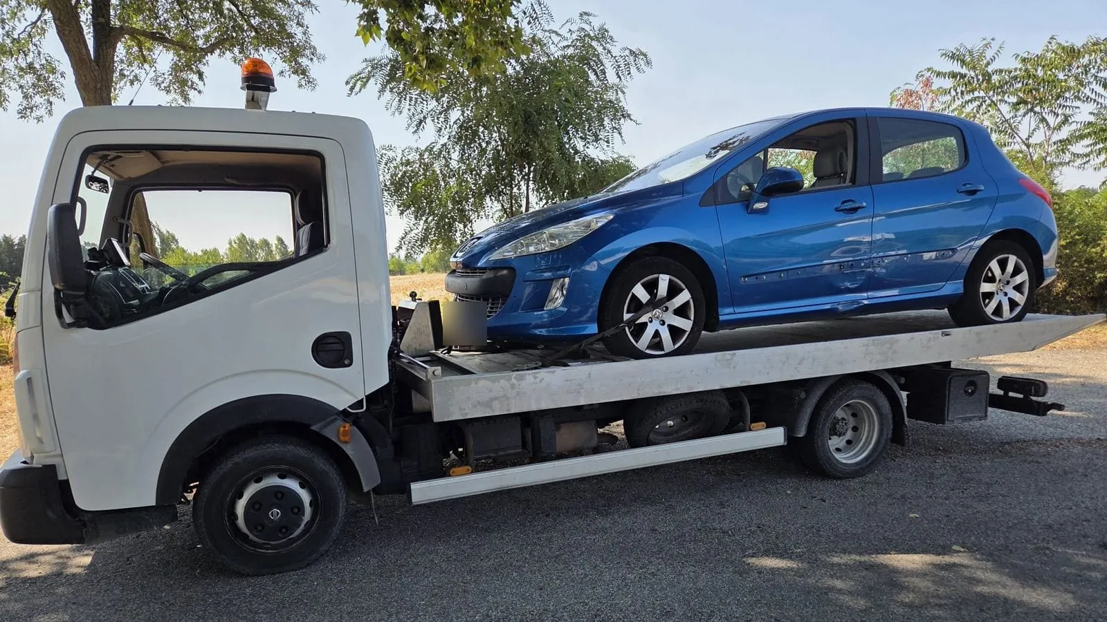 Véhicule accidenté sanglé sur le plateau du camion
